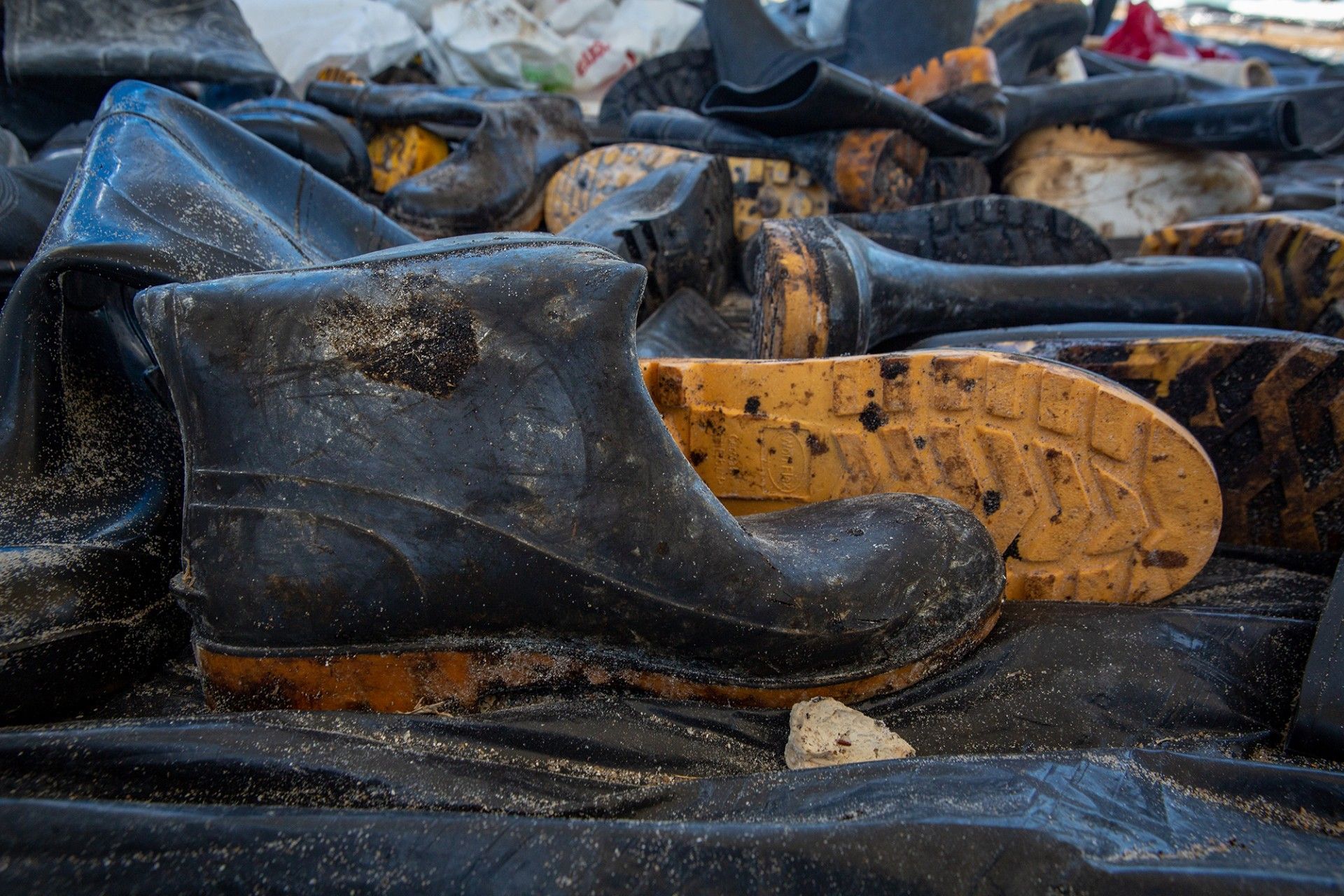 Botas cubiertas de petróleo utilizadas por los voluntarios en la base de limpieza del gobierno en la playa de Itapuama, estado de Pernambuco (Brasil). Crédito: Léo Malafaia/Diálogo Chino